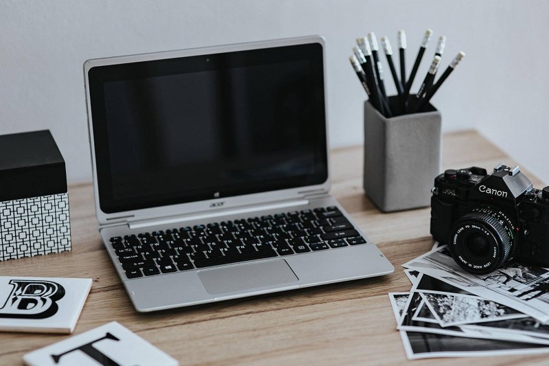 Laptop and video production equipment on a wooden table